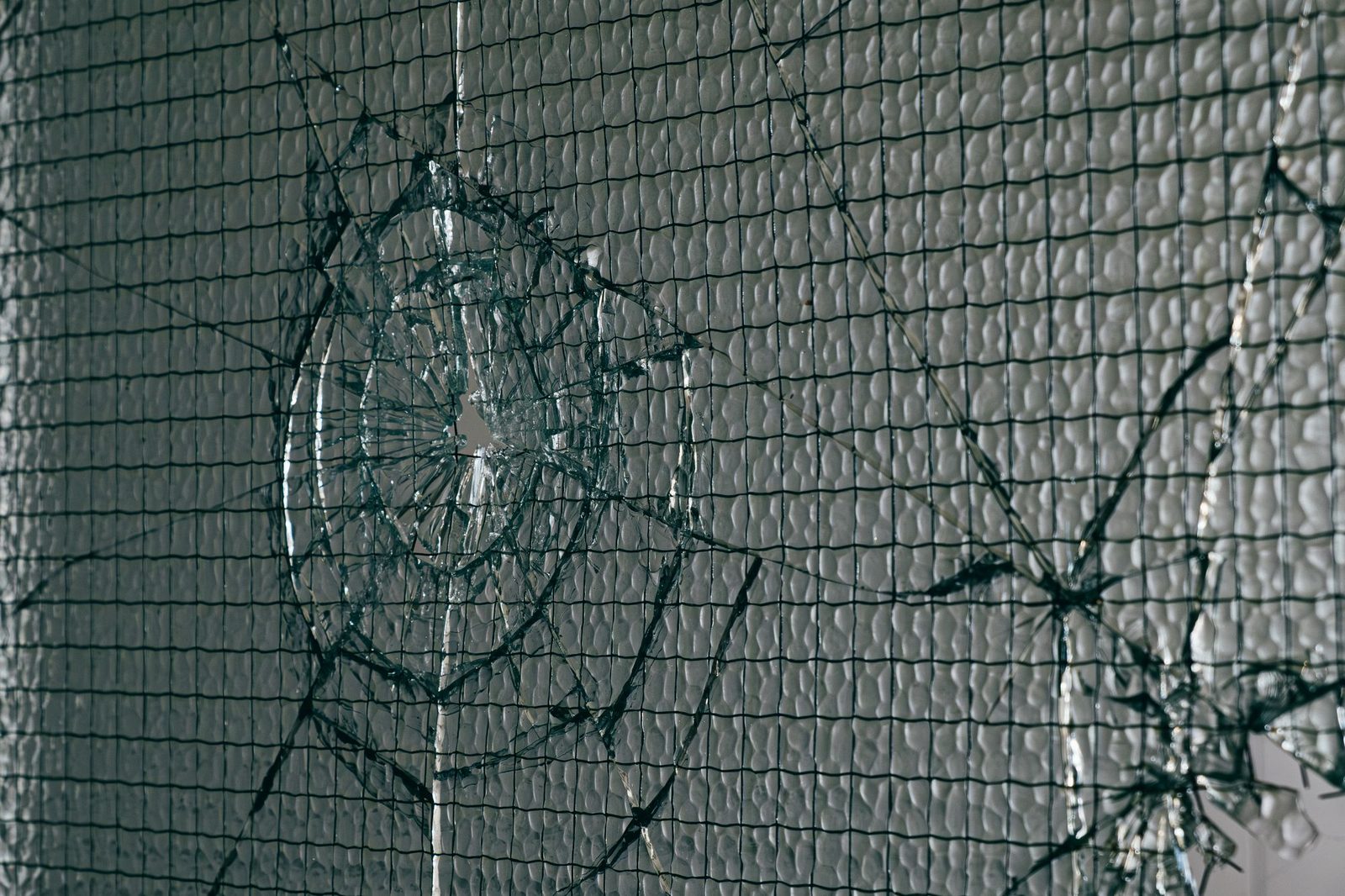 Broken wired glass with a cracked hole